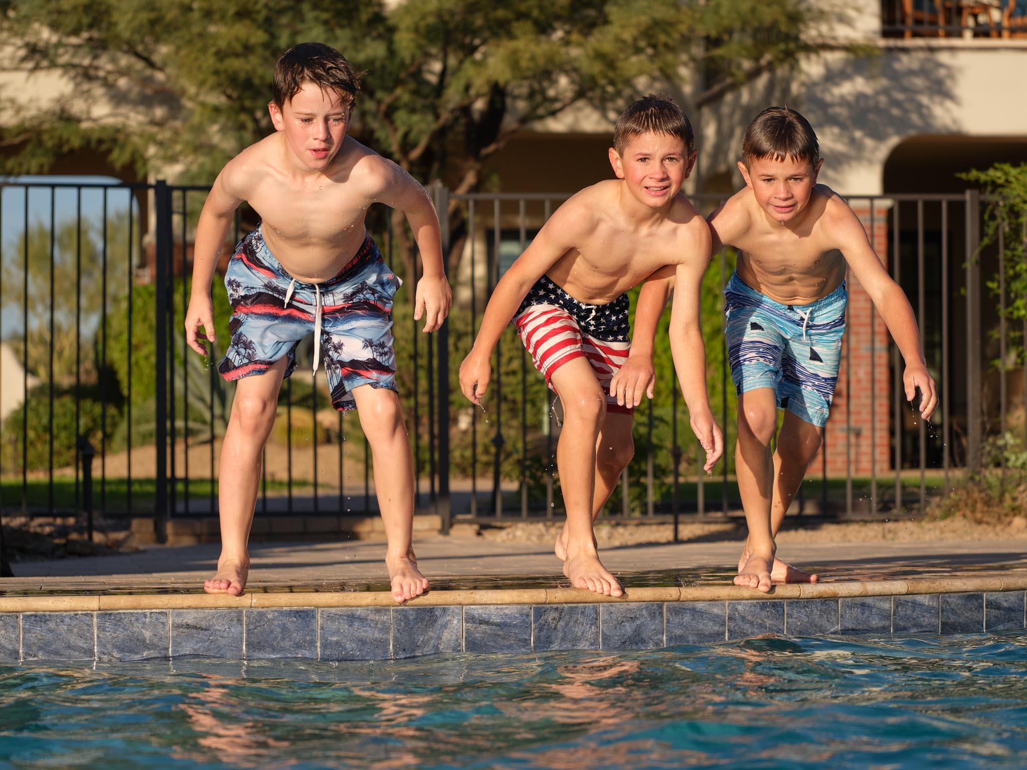 Hospitality photography by Warren Diggles. Kids jumping into the pool at HÓZHÓ Scottsdale.